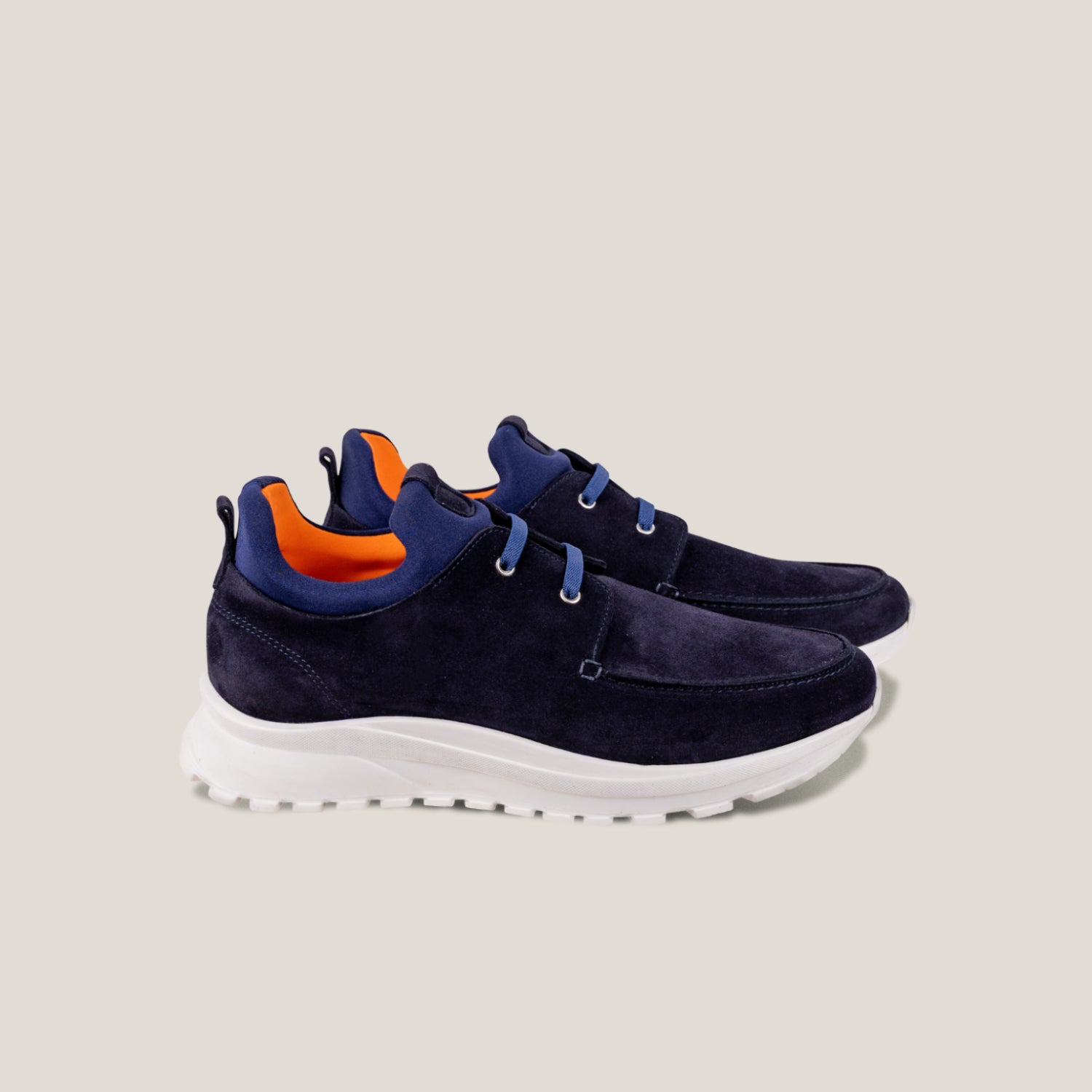 Navy sneakers with orange accents on a light gray background