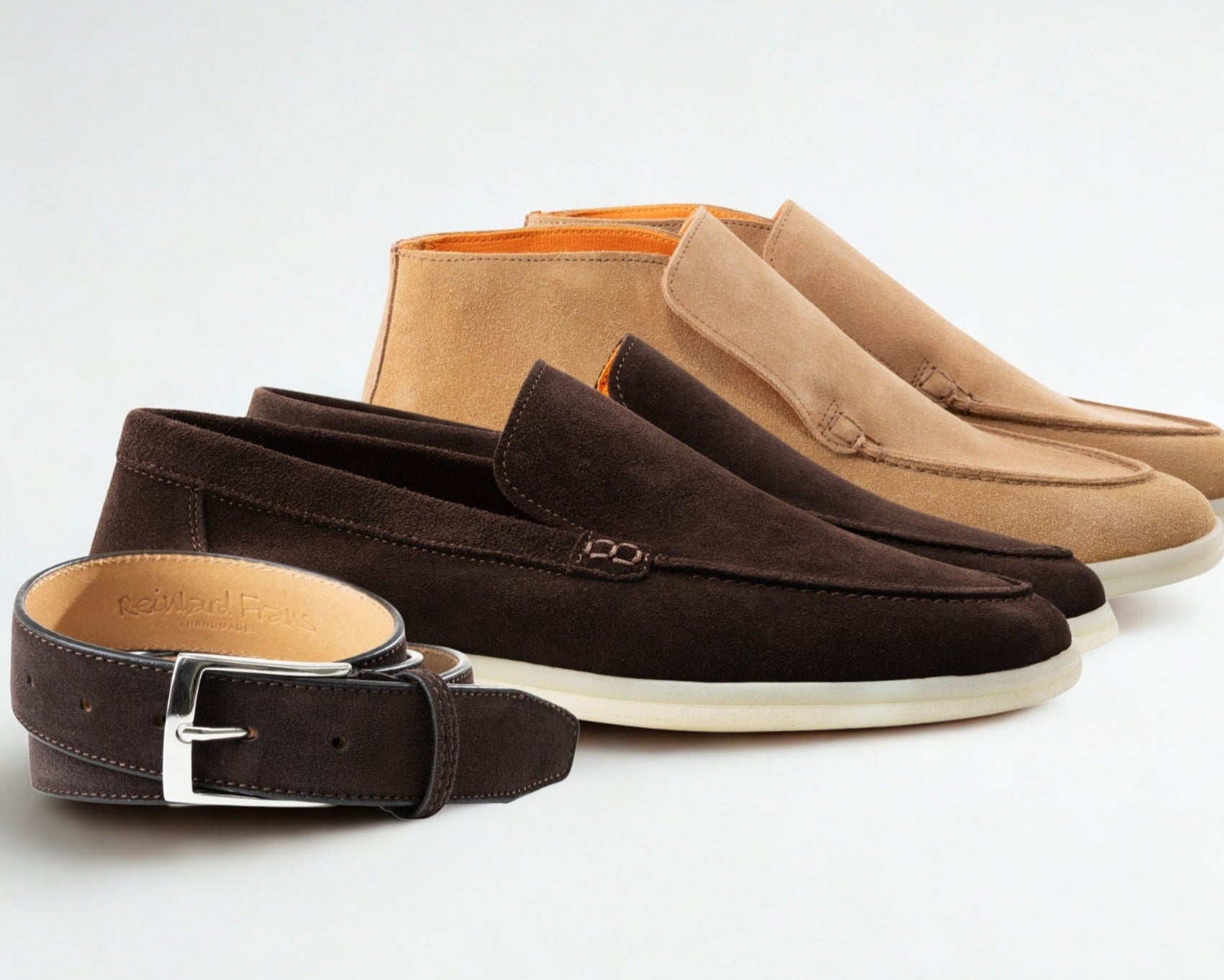 Brown and beige loafers with a belt on a white background