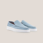 Light blue loafers with white soles on a beige background