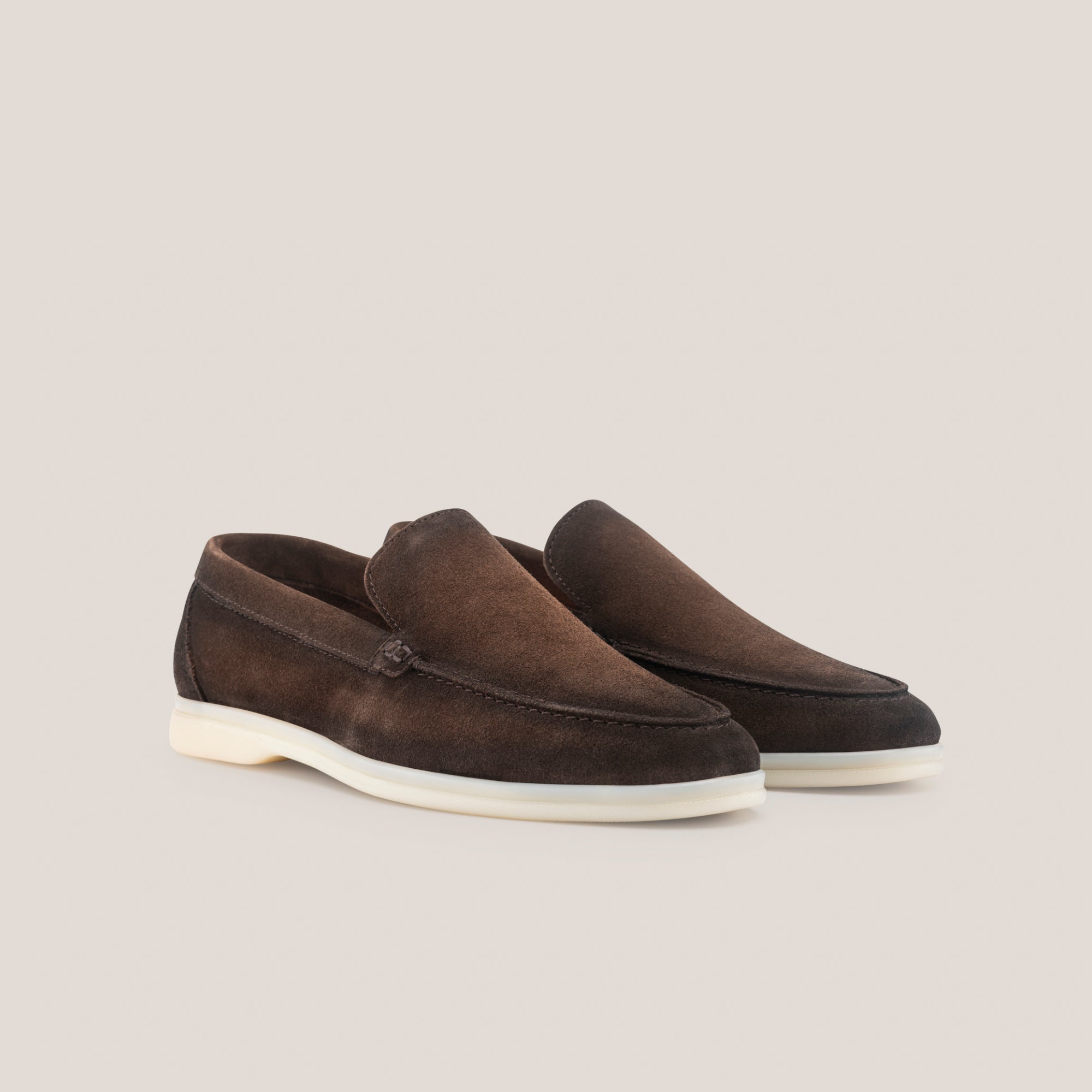 Pair of brown suede loafers on a light gray background