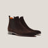 Pair of brown suede Chelsea boots on a light gray background