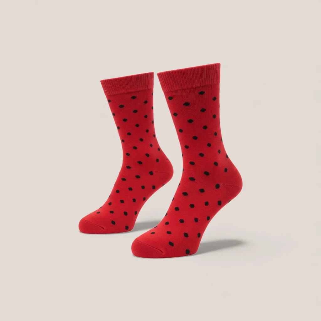 Red socks with black polka dots on a beige background