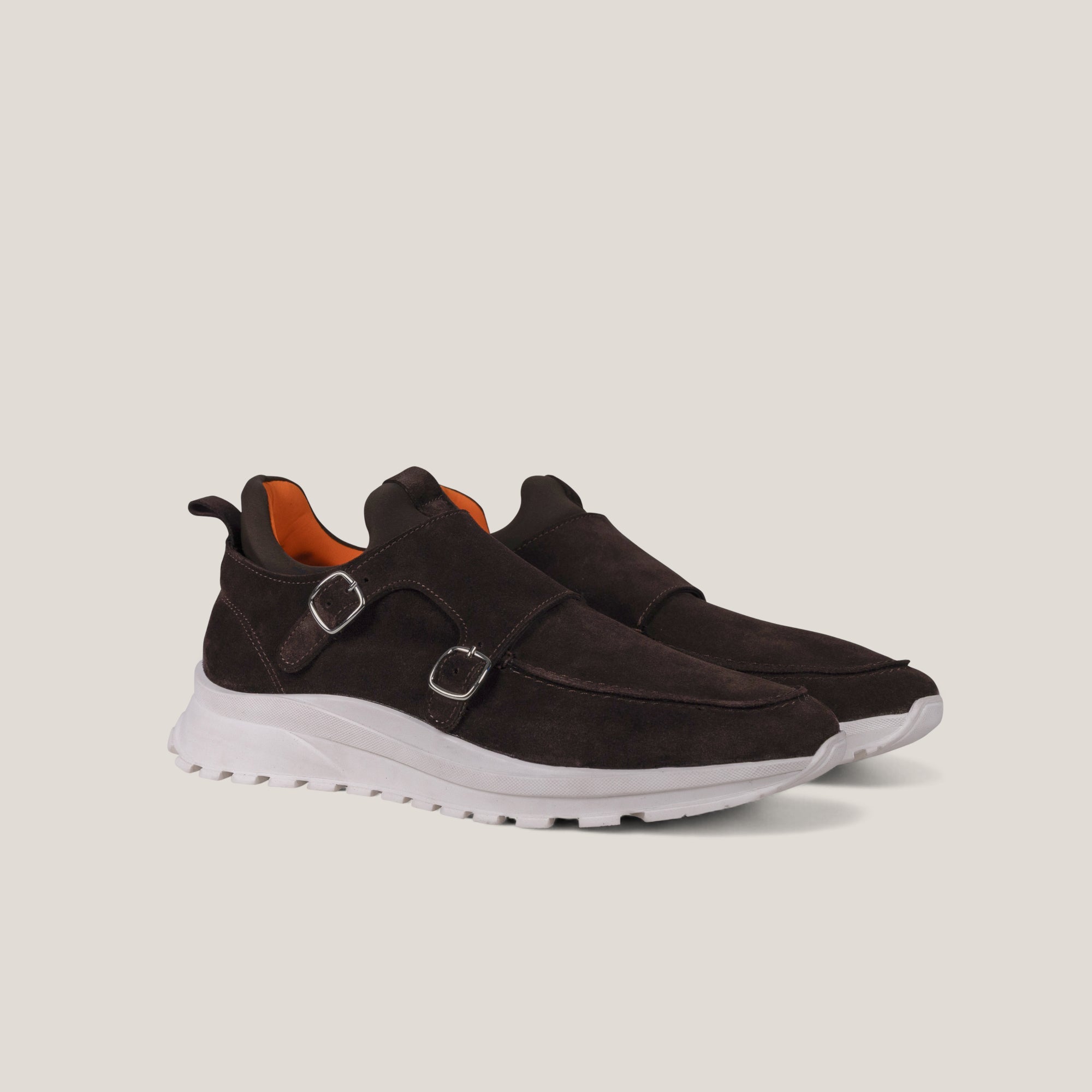Brown slip-on shoes double monkstrap  with white soles on a light gray background